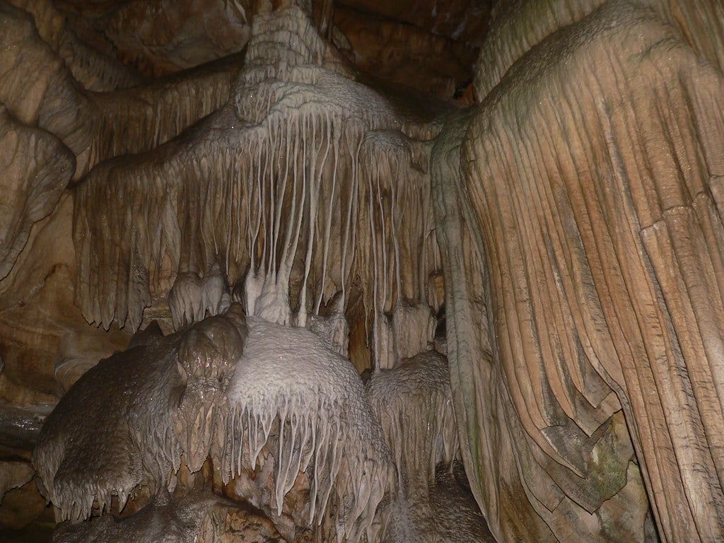 Estalactitas intrincadas y flujos de piedra en cascada cubren las paredes de roca subterráneas dentro de la Cueva Crystal en el Parque Nacional Sequoia.