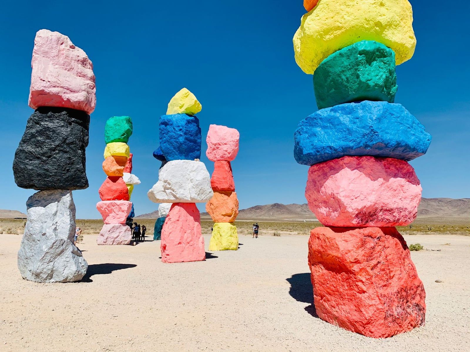 Leuchtende Stapel bemalter Findlinge stehen in der Nevada-Wüste bei Seven Magic Mountains, einem beliebten Straßenstopp auf der Fahrt zum Sequoia-Nationalpark.