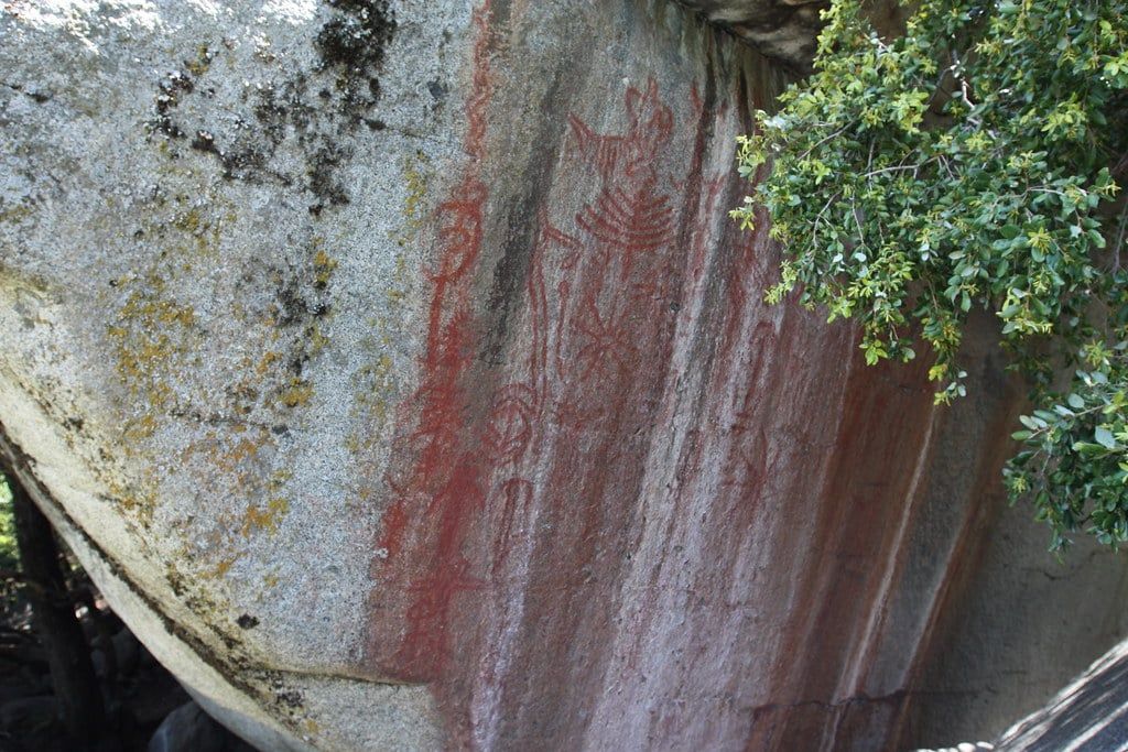 Pictogramas rojos de nativos americanos pintados sobre una gran roca de granito en Hospital Rock, en el Parque Nacional Sequoia.