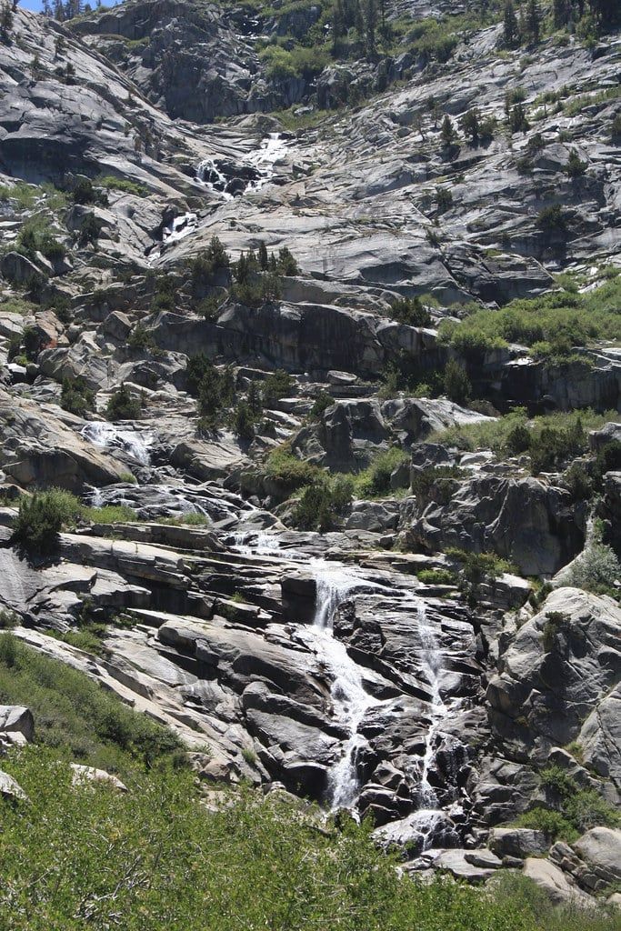 Water cascades down a steep granite headwall at Tokopah Falls in Sequoia National Park.